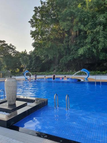 a large blue swimming pool with people in it at Golden Mountain Hostel in Ninh Binh