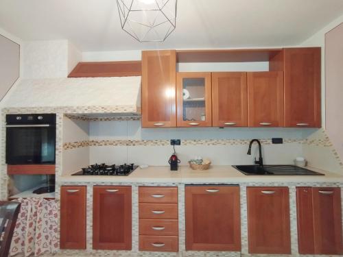 a kitchen with wooden cabinets and a sink at Il nido di Giulia in Montevettolini