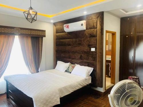 a bedroom with a large bed and a fan at Canal View Hotel in Dargai