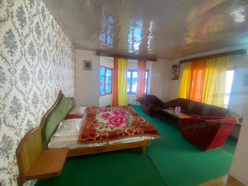 a small bedroom with a bed and a couch at Potala Hotel in Jāmb