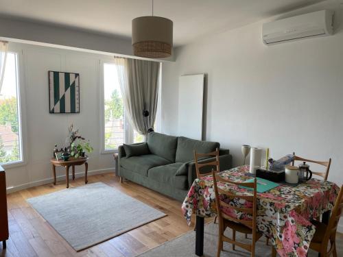 a living room with a green couch and a table at Cozy apartment in Munich in Munich