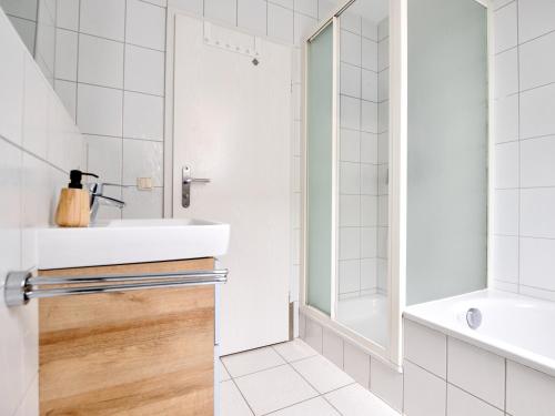 a white bathroom with a sink and a shower at Altstadtflair Beim Schappeler in Memmingen