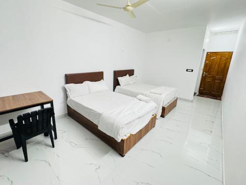 um quarto com 2 camas, uma secretária e um tecto em eden homestay em Munnar