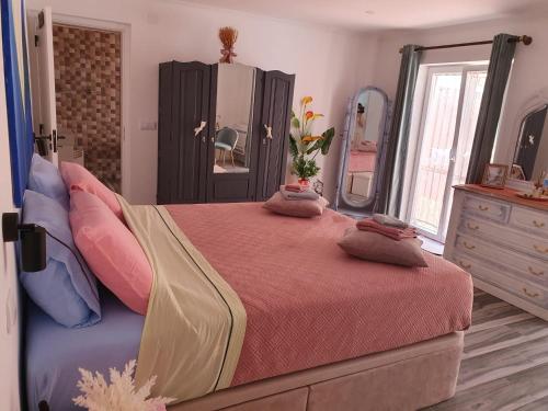 a bedroom with a bed and a dresser and a mirror at Casa do Arelho in Óbidos