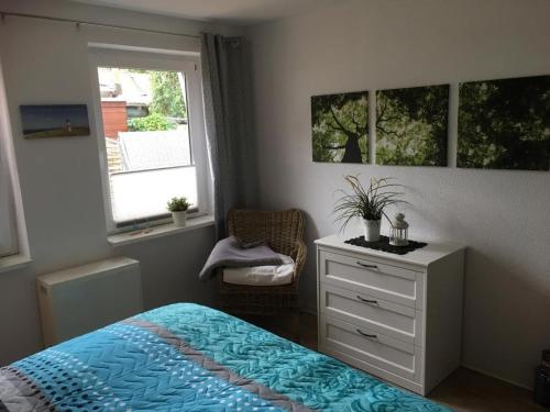 a bedroom with a bed and a dresser and a window at Olivia in Rheinsberg