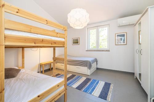 una camera con 2 letti a castello e un lampadario a braccio di Holiday house VILLA ANTON with private pool a Kras
