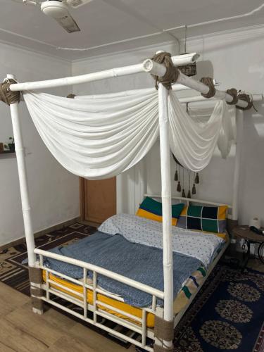 达兰萨拉Friend circle cafe and homestay dharamsala的带白色蚊帐的白色天蓬床