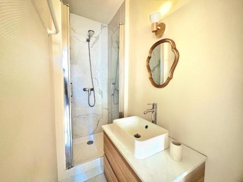 een badkamer met wastafel en douche met spiegel bij Le Marceau in Angers
