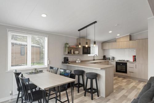 a kitchen with a table and chairs and a counter top at Modern Lodge nr Ilfracombe & Beaches in West Down