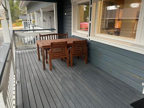 einem Holztisch und einer Bank auf der Veranda eines Hauses in der Unterkunft Ruka Snow&Sun 3 - 2 ski tickets included in Kuusamo