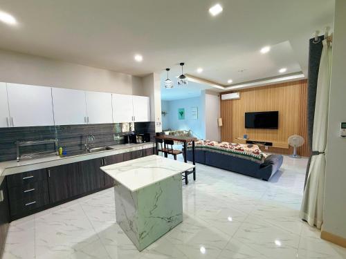 a large kitchen and living room with a couch at Aonang nine poolvilla in Ao Nang Beach