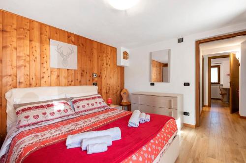 a bedroom with a red bed with towels on it at Maison du coeur - Bien-être in Challand Saint Anselme