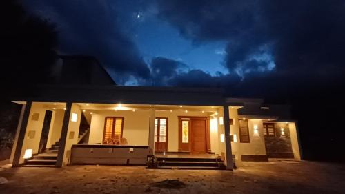 a house at night with the lights on at Dolmens castle in Marayoor
