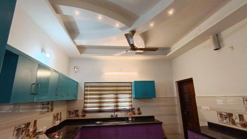 a kitchen with blue cabinets and a ceiling at Dolmens castle in Marayoor