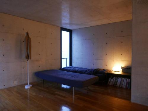 生駒市にあるOne Floor Designed by Architect Tadao Andoのベッドとテーブルがある部屋