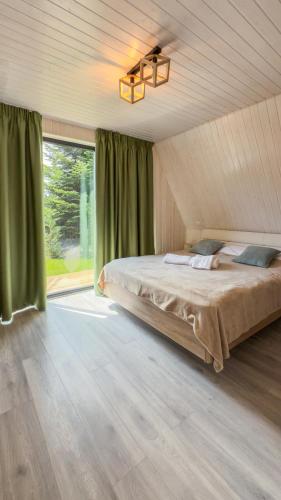 a bedroom with a bed and a large window at A-Frame Valley in Buşteni