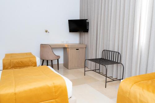 a hotel room with a bed and a desk and a television at hôtel LE PACHA in Tunis