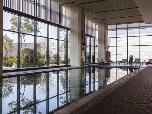 a large building with a pool of water and windows at Pullman Fuzhou Tahoe in Fuzhou