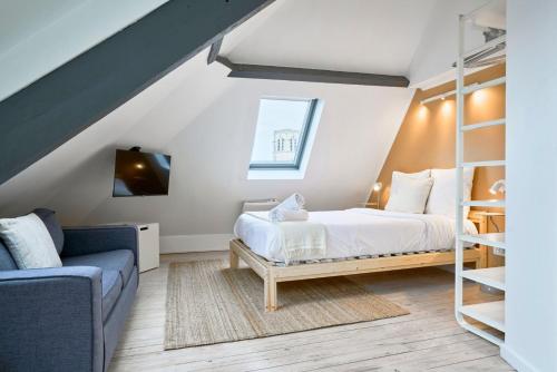 ein Schlafzimmer mit einem Bett und einer Couch in der Unterkunft Studio mansardé à deux pas de la Citadelle in Lille