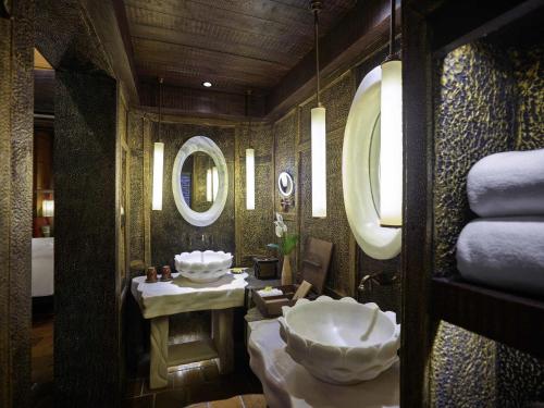 a bathroom with two sinks and a mirror at Legacy Yen Tu - MGallery in Uông Bí