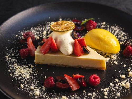 a piece of cheesecake with fruit on a plate at Palladio Hotel Buenos Aires - MGallery Collection in Buenos Aires