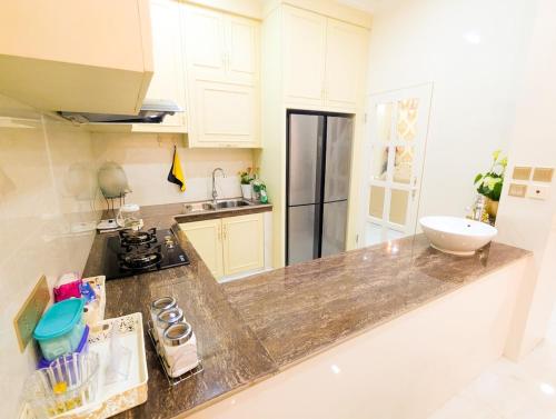 バタム・センターにあるLovina C3 no 8 at Tropicana Residenceのキッチン(シンクと冷蔵庫付きのカウンター付)