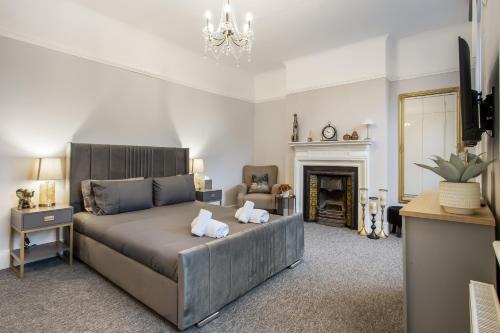a bedroom with a large bed and a fireplace at The Grand Victorian 3 Bedroom Apartment in Edgware