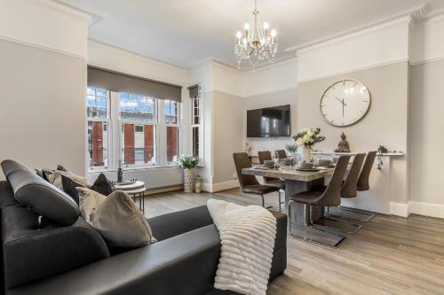 a living room with a couch and a dining room at The Grand Victorian 3 Bedroom Apartment in Edgware