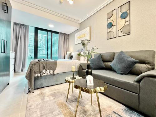 a living room with a couch and a bed at Cosmos Living Delightful Studio with Balcony in Dubai