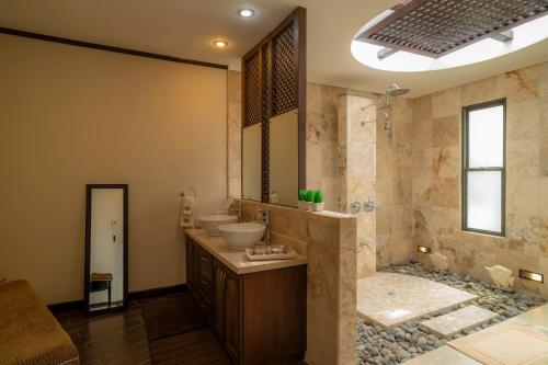 Un baño con dos lavabos y una ducha. en Casa Plazoleta 4 bdr private pool in Los Suenos, en Herradura