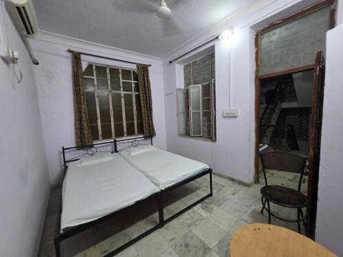 a small room with a bed and a chair at Sharib House in Ajmer