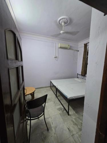 a room with a bed and a table and a chair at Sharib House in Ajmer