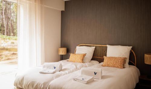 two twin beds in a room with a window at Villa La Perle in Talmont