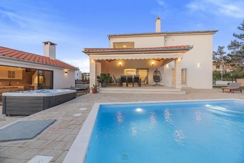 a swimming pool in front of a house at Villa Kunfin ZadarVillas in Bibinje