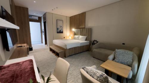 a hotel room with a bed and a couch at منازل صوان للوحدات السكنية in Al Shafa