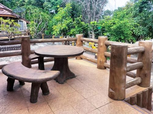 a table and two benches sitting next to a fence at Bhumisiri Hill Khaoyai in Ban Tha Chang