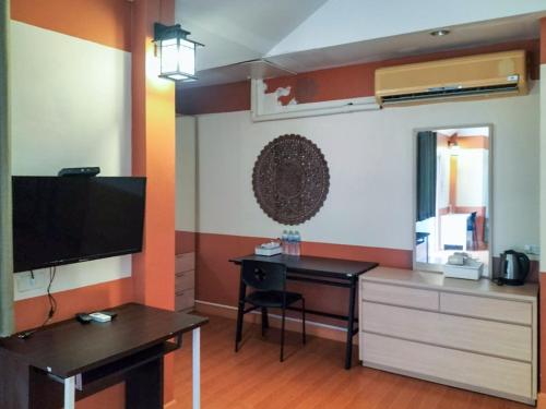 a room with a desk and a television in a room at Bhumisiri Hill Khaoyai in Ban Tha Chang