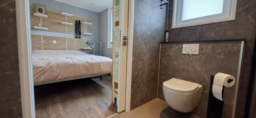Un dormitorio pequeño con una cama y un baño. en Charmant Chalet met privétuin in Someren - VP063, en Someren