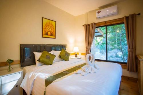 a bedroom with two beds and a window at Bhumisiri Hill Khaoyai in Ban Tha Chang