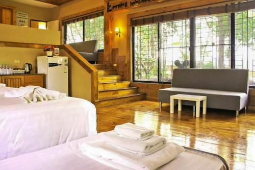 a room with two beds and a couch and a table at Bhumisiri Hill Khaoyai in Ban Tha Chang