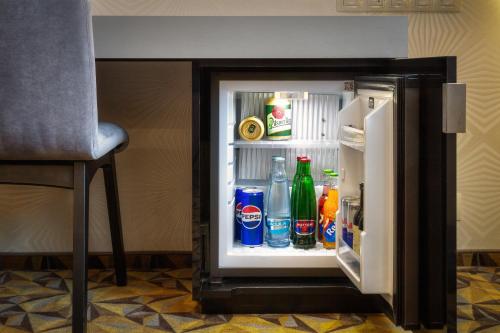 an open refrigerator filled with soda and drinks at Hotel Essence in Prague