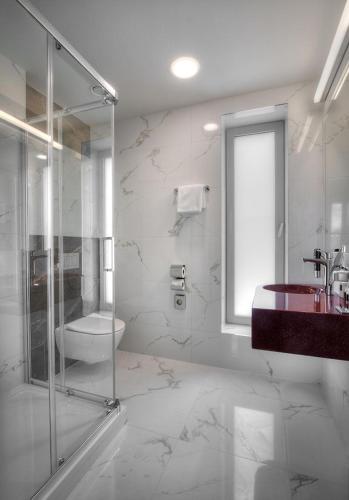 a bathroom with a glass shower and a sink at Hotel Essence in Prague