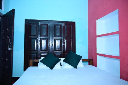 a bedroom with a white bed with a black headboard at Aashirwad paying guest house in Ayodhya