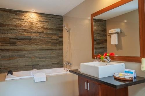 a bathroom with a sink and a tub and a mirror at Swiss-Belvillas Umalas in Canggu