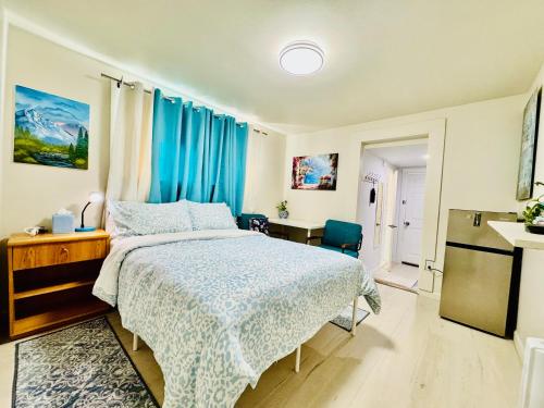 ein Schlafzimmer mit einem Bett mit einer blauen Bettdecke in der Unterkunft Cozy 1 Bedroom Mini Apartment 10 Mins to SeaTac Airport in Seattle