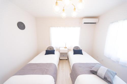 two beds in a room with a window at Miraie Yatomi Large house in Yatomi