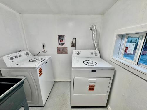 eine kleine Küche mit weißen Geräten und einem Fenster in der Unterkunft Cozy 1 Bedroom Mini Apartment 10 Mins to SeaTac Airport in Seattle