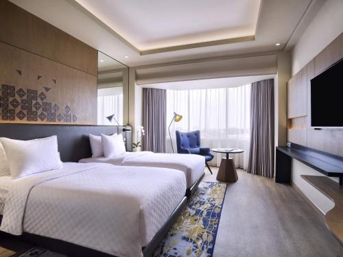 Ένα ή περισσότερα κρεβάτια σε δωμάτιο στο Mercure Jakarta Batavia