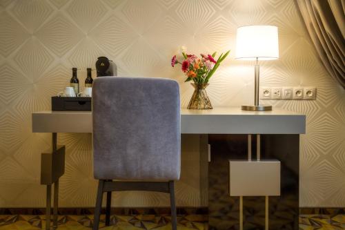 a table with a blue chair and a lamp at Hotel Essence in Prague