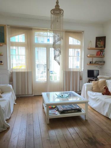 a living room with a coffee table and a chandelier at La Maison Blanche – Plage et centre in Fouras